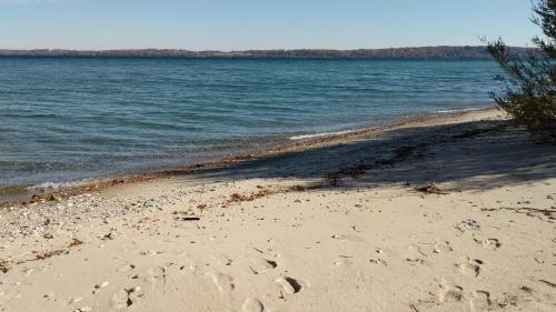 a beach with footprints in the sand and water at Anchor Inn in Traverse City