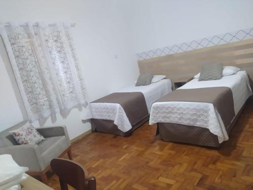 a room with two beds and a couch in it at HOTEL CANTO DO CHAFARIZ in Diamantina