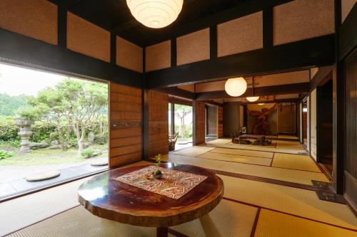 a room with a wooden table and a large window at The Ninja Mansion in Toyota