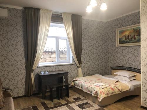 um quarto com uma cama e uma janela em Keruen em Taraz