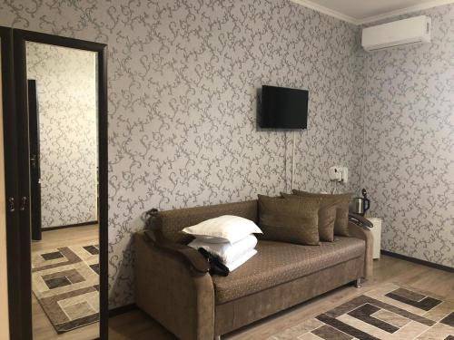 a living room with a couch and a television at Keruen in Taraz