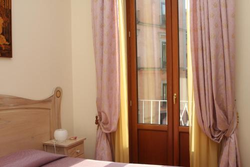 a bedroom with a window and a wooden door at Divina House B&B in Sorrento