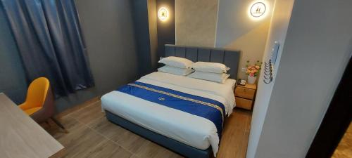 a bedroom with a bed with white sheets and pillows at GOOD 9 HOTEL - Cahaya Kota Puteri in Pasir Gudang