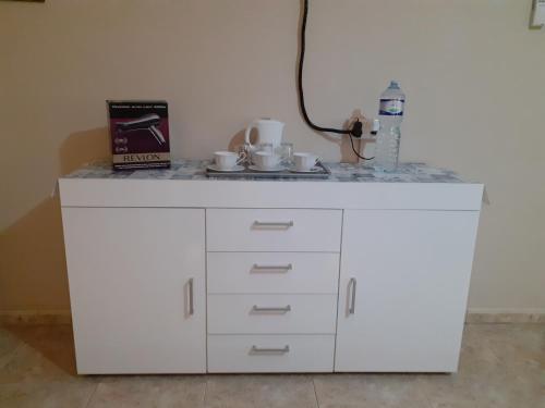 a white cabinet with cups on top of it at Black Gold Private Room in Msida