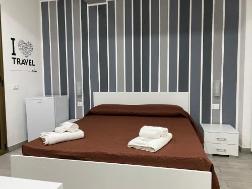 a bedroom with a bed with towels on it at IN CENTRO ROOMS Vicino Cefalù SELF-CHEK-IN in Campofelice di Roccella