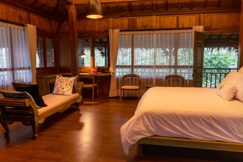 a bedroom with a bed and a table and chairs at Tira Vilagna Suites & Spa in Kintamani