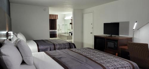 a hotel room with two beds and a flat screen tv at Key West Inn - Boaz in Boaz