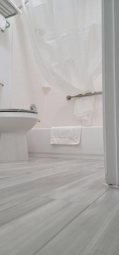uma casa de banho branca com um WC e uma toalha em Key West Inn - Boaz em Boaz