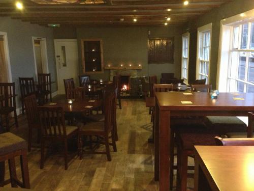 a restaurant with wooden tables and chairs in a room at The Ferry Boat Inn in Ullapool