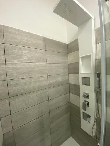 a bathroom with a shower with wood paneling at IN CENTRO ROOMS Vicino Cefalù SELF-CHEK-IN in Campofelice di Roccella