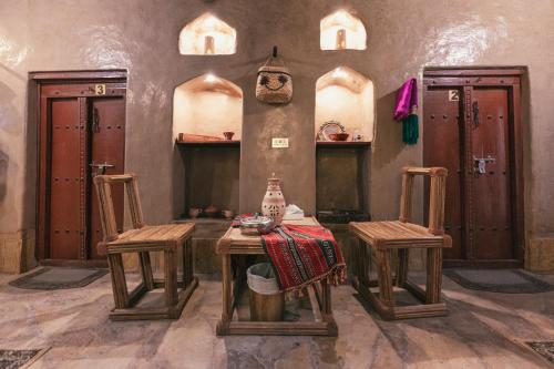 Bait Al Aqr في نزوى‎: غرفة مع طاولة وكرسيين في غرفة