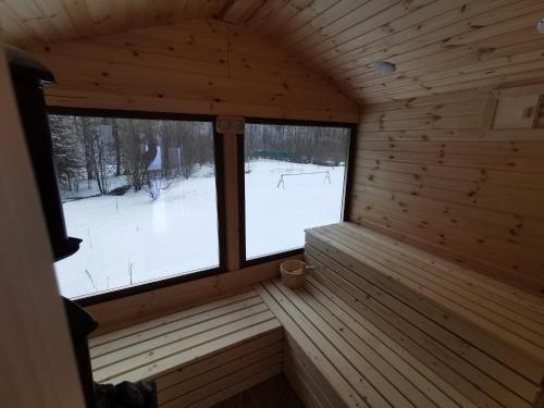 an inside view of a wooden cabin with two large windows at Pensiunea Ioana in Borlova
