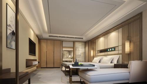 a hotel room with a bed and a couch at Shangrao International Hotel in Shangrao