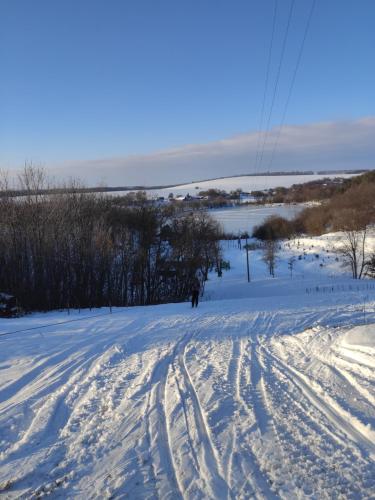 a person cross country skiing down a snow covered slope at Zelenaya Usad`ba StavBor in Zavadivka