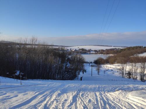 a snow covered road with tracks in the snow at Zelenaya Usad`ba StavBor in Zavadivka