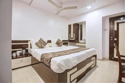 a bedroom with a large bed with a ceiling fan at Hotel City View in Navi Mumbai