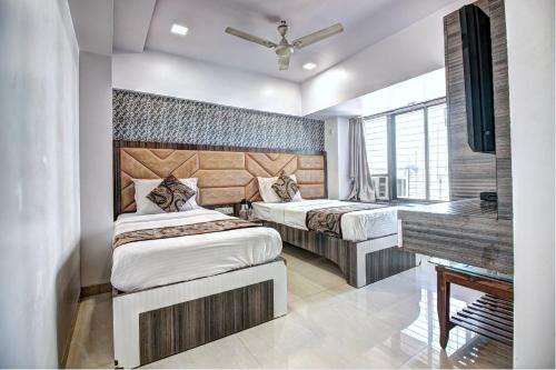 a bedroom with two beds and a desk and a piano at Hotel City View in Navi Mumbai