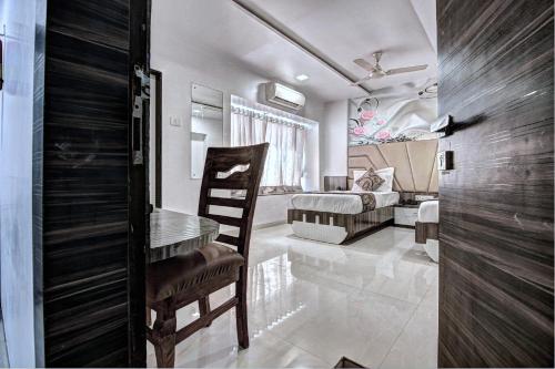 a room with a table and a chair and a couch at Hotel City View in Navi Mumbai