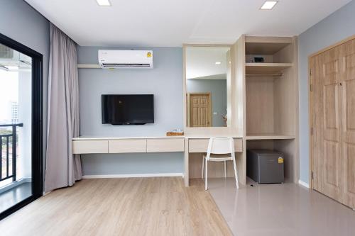 a room with a desk with a tv and a mirror at Napa Hotel Ratchaburi in Ratchaburi