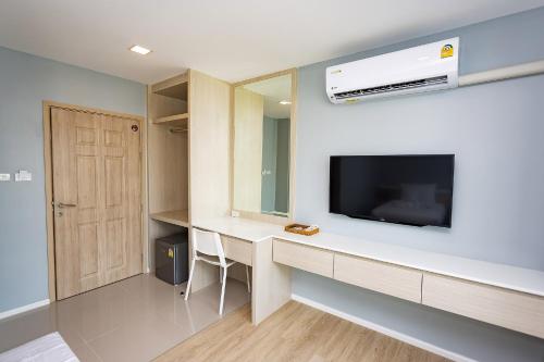 a room with a desk with a tv and a mirror at Napa Hotel Ratchaburi in Ratchaburi