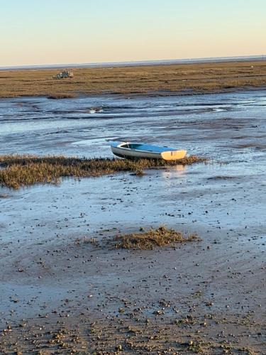 a boat sitting on the shore of a beach at Hôtel la petite auberge in Arès
