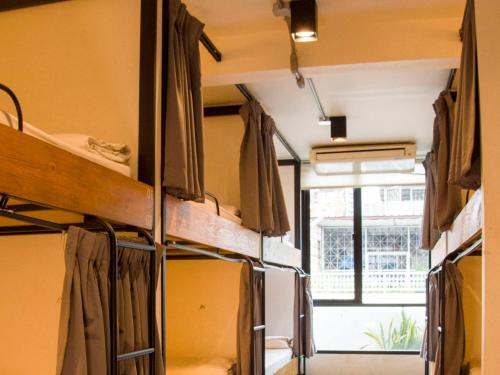 a group of bunk beds in a room with a window at HOLY SHEET Hostel in Bangkok