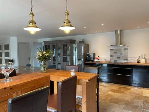 une cuisine avec une grande table et des chaises en bois dans l'établissement Le Domaine du Sillon, à Mont-Dol