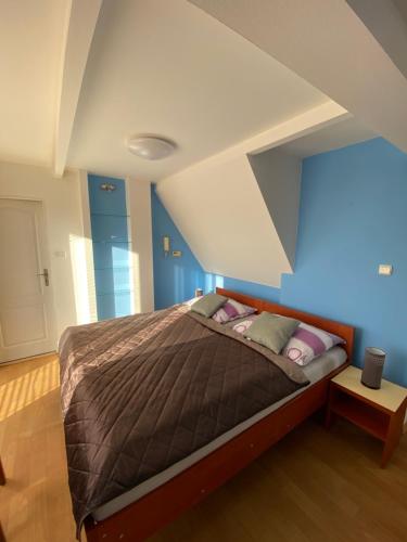 a bedroom with a bed with a blue wall at Penzion SLUNCE in Česká Lípa
