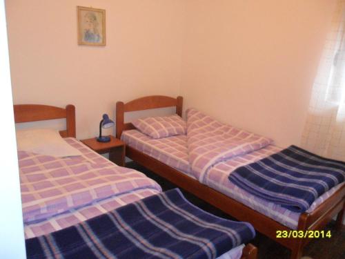 two beds in a small room with at Apartments Sara in Žabljak