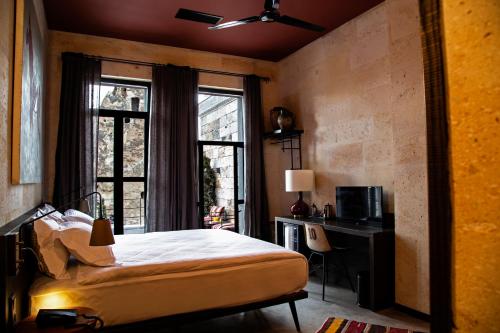 a bedroom with a bed and a desk and a window at Carus Cappadocia in Goreme