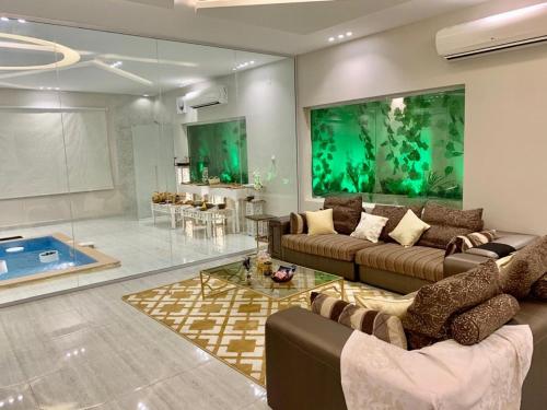 a living room with two couches and a swimming pool at شالية فاخر بمسبح خاص بمكة المكرمة in Makkah