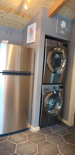 a laundry room with a refrigerator and a washer and dryer at Entire Tiny Home close to cruise ship terminal Alaska Railroad and downtown Seward in Seward