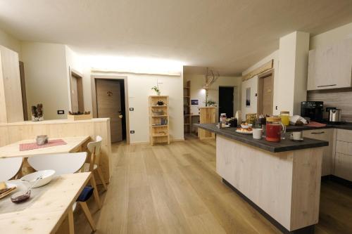 a large kitchen with a counter top and a table at B&B Le Ciorciole in Tesero