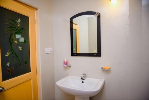 a bathroom with a sink and a mirror on the wall at Double Lake View Tissa & Safari in Tissamaharama