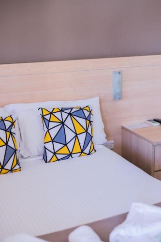 a bedroom with a bed with pillows on it at Kite Street Units - Contactless Check in in Orange
