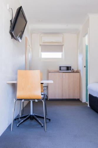 an empty room with a table and a chair at Kite Street Units - Contactless Check in in Orange