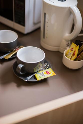 a counter with two cups and a plate on it at Kite Street Units - Contactless Check in in Orange