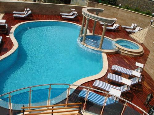a swimming pool on a cruise ship with lounge chairs at Twins Palace ApartHotel in St. St. Constantine and Helena