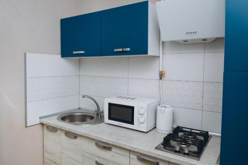a kitchen with a sink and a microwave at STAR HOME Прокофьева 16 корп2 in Sumy