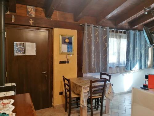 a dining room with a table and chairs and a door at Il Castagneto in Camerino