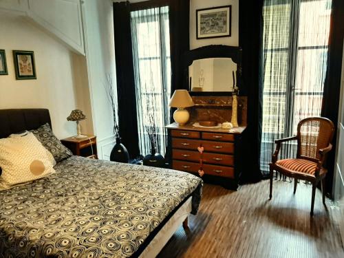een slaapkamer met een bed, een dressoir en een spiegel bij Les Clefs de la Liberté in Colmar