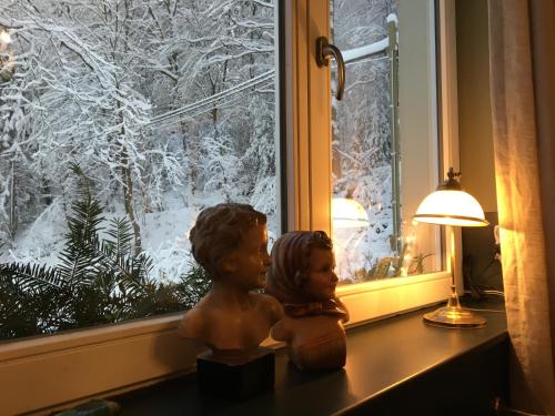 a couple of statues sitting on a window sill at La Villa du Pré Du Cerf in Spa