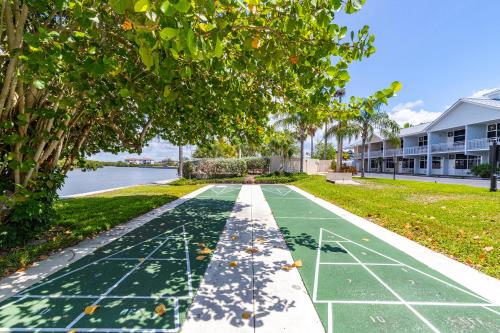 a tennis court in front of a house with a tree at The Blue Lagoon in Ruskin