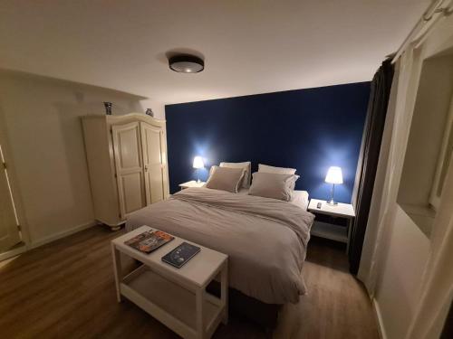 een slaapkamer met een bed met een blauwe muur bij Hoeve Zandbelt in Markelo