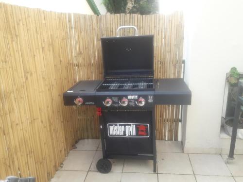 a black barbecue grill in front of a fence at Oren's place - perfect for families & friend's in Kefar Weradim