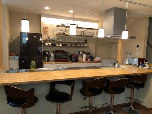 a kitchen with a counter with bar stools at Art Inn 24 Sapporo in Ōdōri