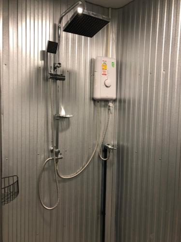 een badkamer met een douche met een douchekop bij Thara Hidden Camp in Khao Kho
