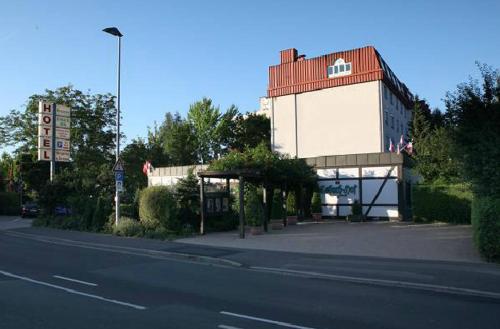 a building with a red roof next to a street at Hotel-Restaurant Esbach Hof in Kitzingen