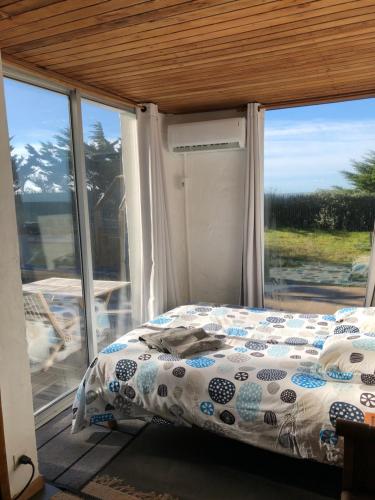 a bedroom with a bed in front of a window at La Mer & La Dune in LʼÉpine