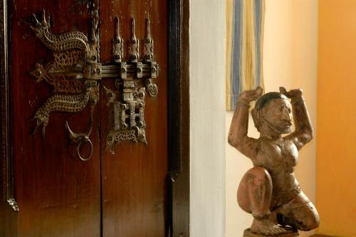 a statue of a man standing next to a door at Malabar House in Cochin